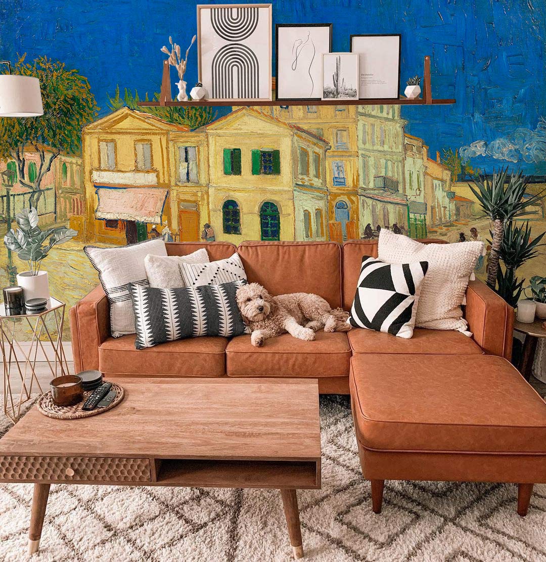 Vintage mural wallpaper in blue and earth tones, vintage sofa, wooden table, modern artwork.