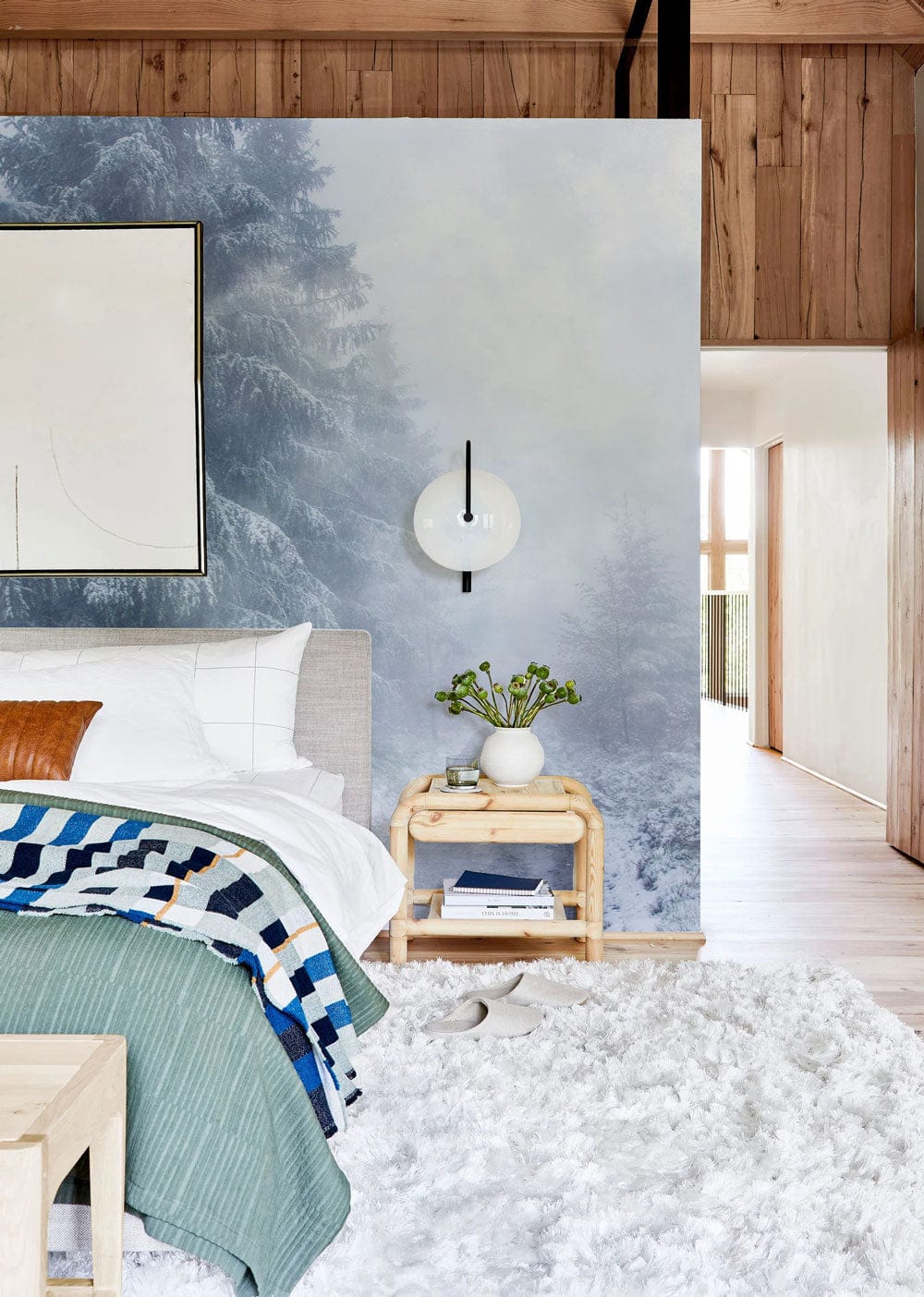 Mystical Winter Wonderland Mural Wallpaper, serene blue; cosy bedroom with rug, wooden flooring, neutral decor.