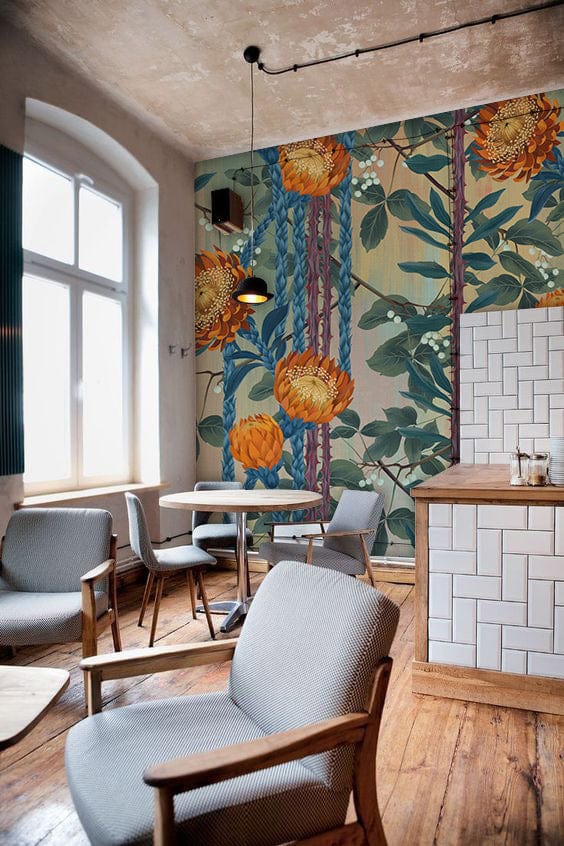 Vintage Botanical Bliss Orange Flowers Mural Wallpaper in rustic lounge with grey chairs and wooden flooring.