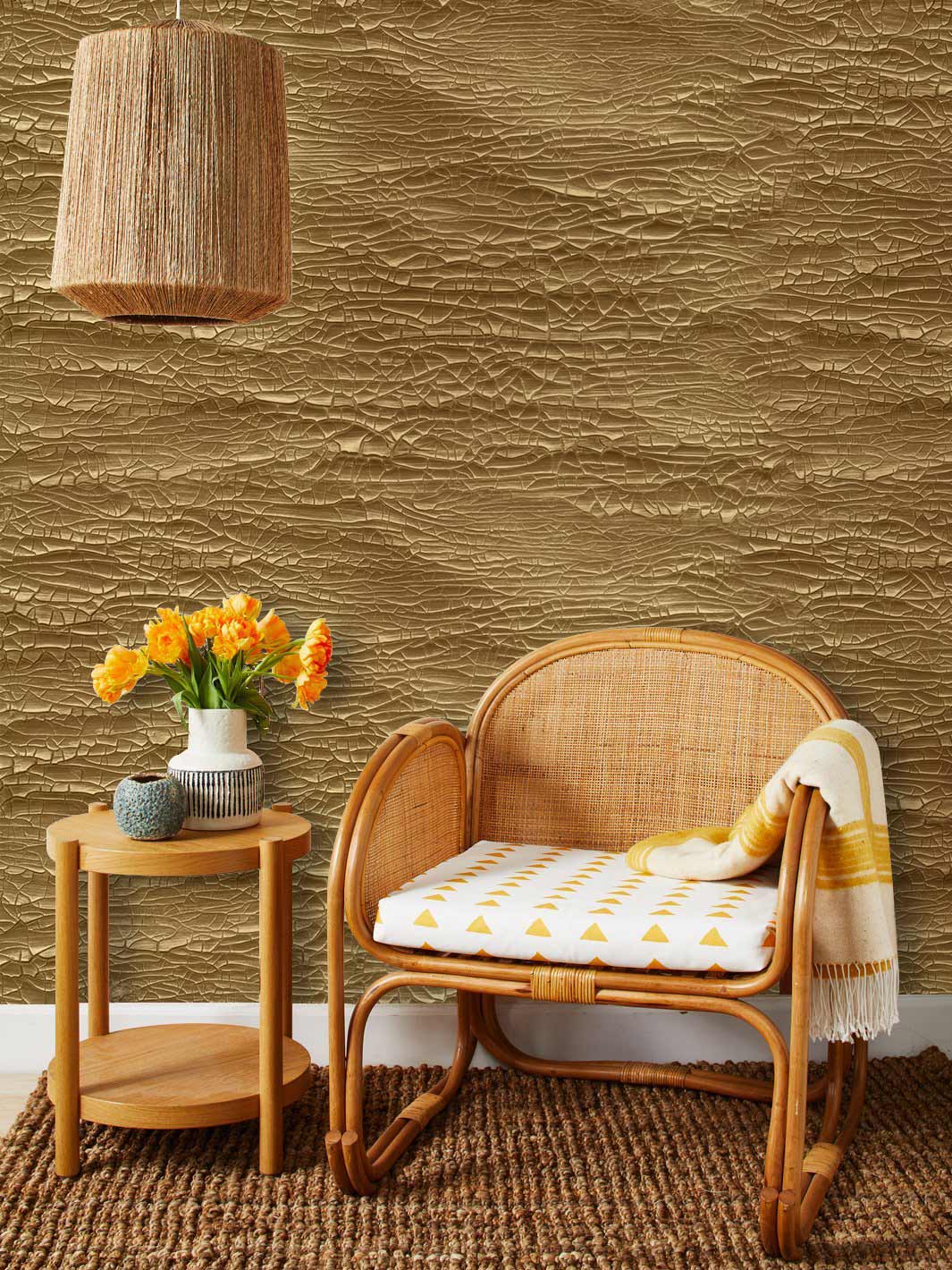 Luxurious gold textured wallpaper, elegant interior decor with wicker chair and table, warm, cosy room.