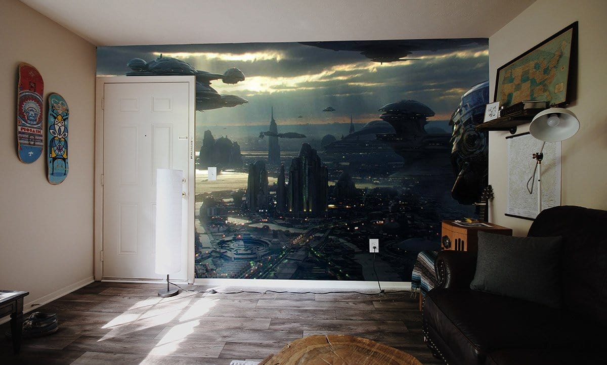 Futuristic metallic cityscape mural wallpaper in living room with dark sofa and wooden flooring.