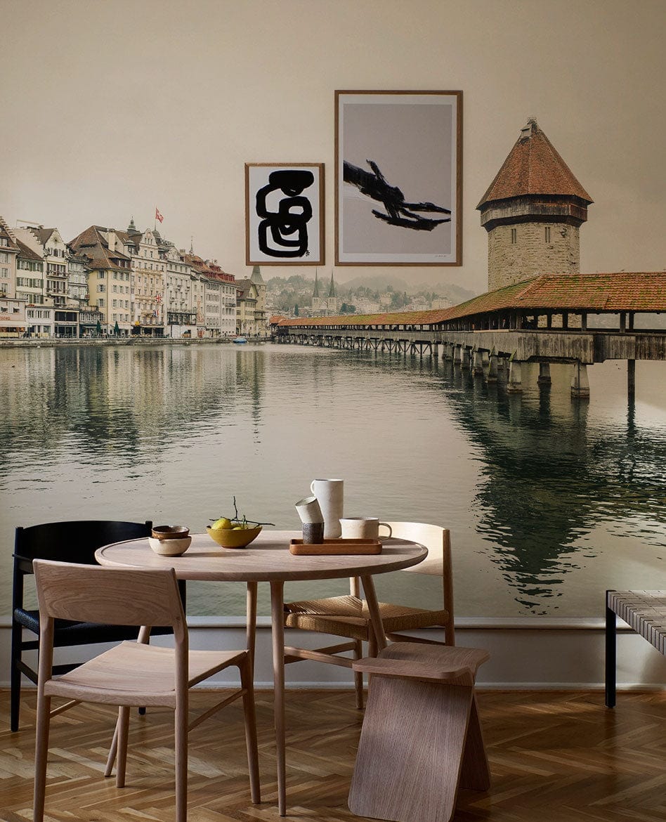 Vintage European mural wallpaper with lakeside architecture, dining room with wooden furniture, parquet flooring.