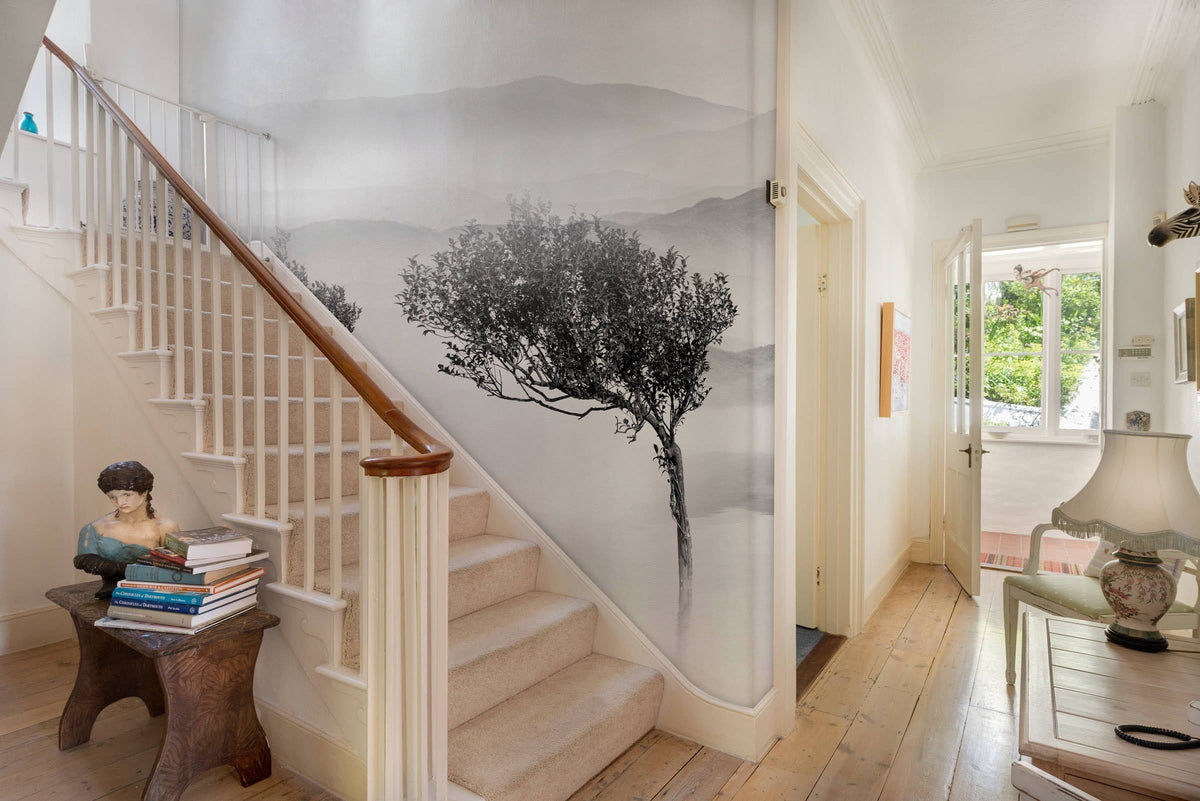 Serene mural wallpaper in hallway with wooden floor, staircase; tranquil landscape decor enhances space.
