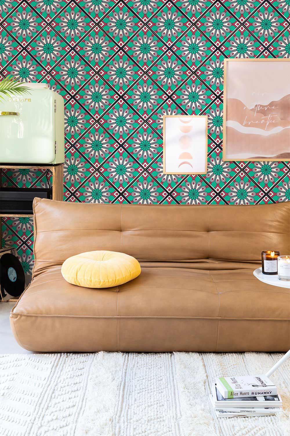 Turquoise and pink floral wallpaper accentuates retro lounge with tan leather sofa and textured rug.