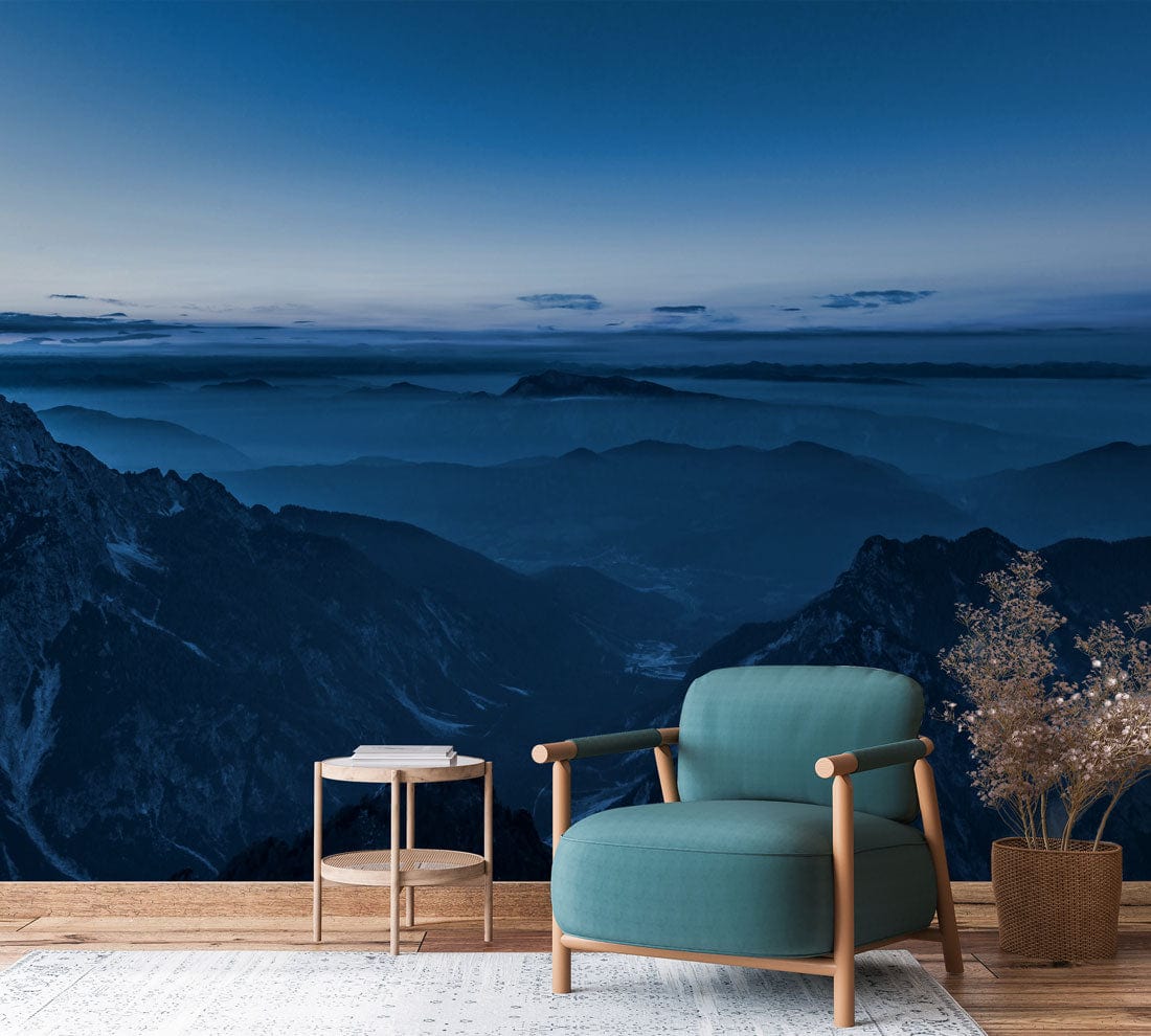 Serene Blue Mountain Mural Wallpaper in living room with teal armchair and light wooden flooring.