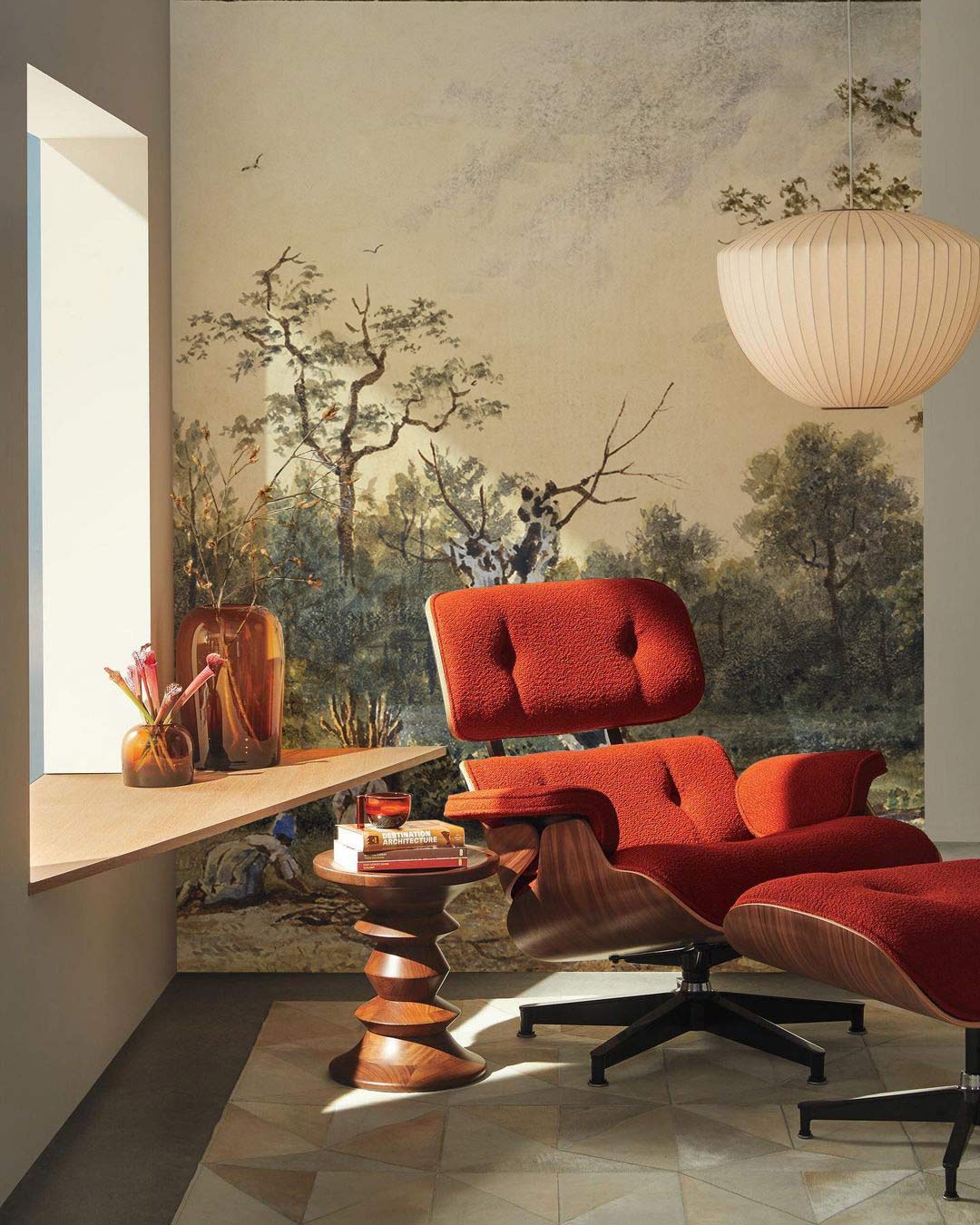 Vintage pastoral landscape mural wallpaper, earthy tones, classic interior, red armchair, geometric floor tiles.