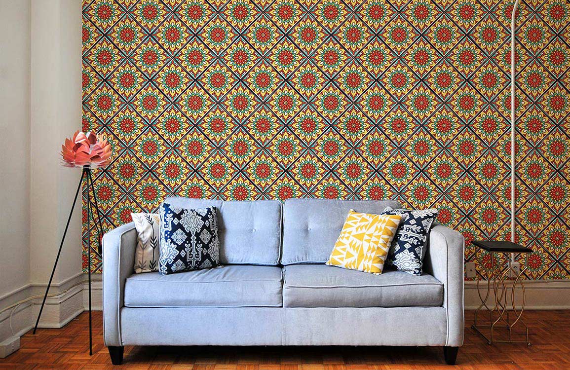 Multicoloured geometric floral wallpaper, Moroccan style; grey sofa, parquet flooring, cushion accents.