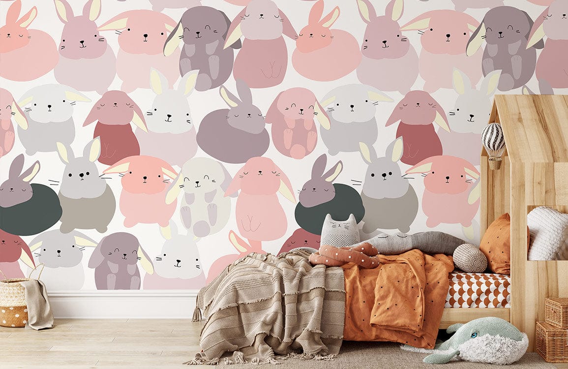 Playful pastel bunny mural wallpaper in children's nursery, featuring wooden bed and soft furnishings.