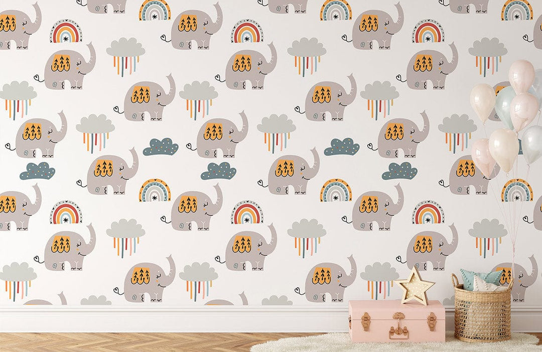 Playful elephant and rainbow nursery wallpaper with wicker basket and pink trunk in child's room.