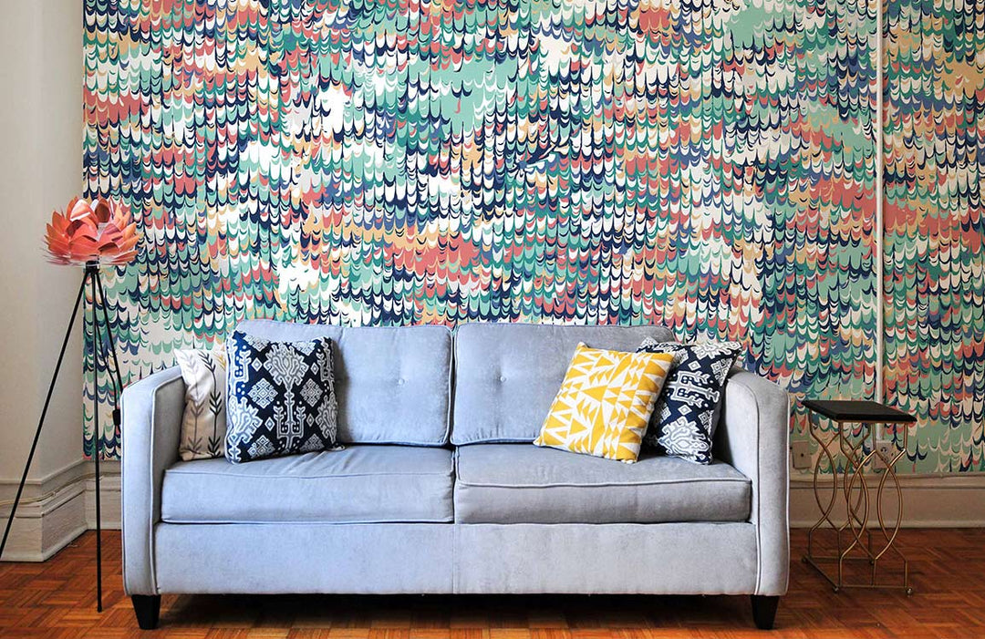 Vibrant Watercolour Waves mural wallpaper design, blue sofa, patterned cushions, parquet flooring, modern decor.