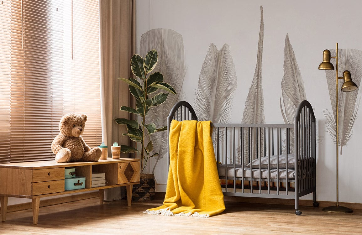Cosy nursery with feather wallpaper, grey cot, mustard throw, wooden flooring, and minimalist decor.