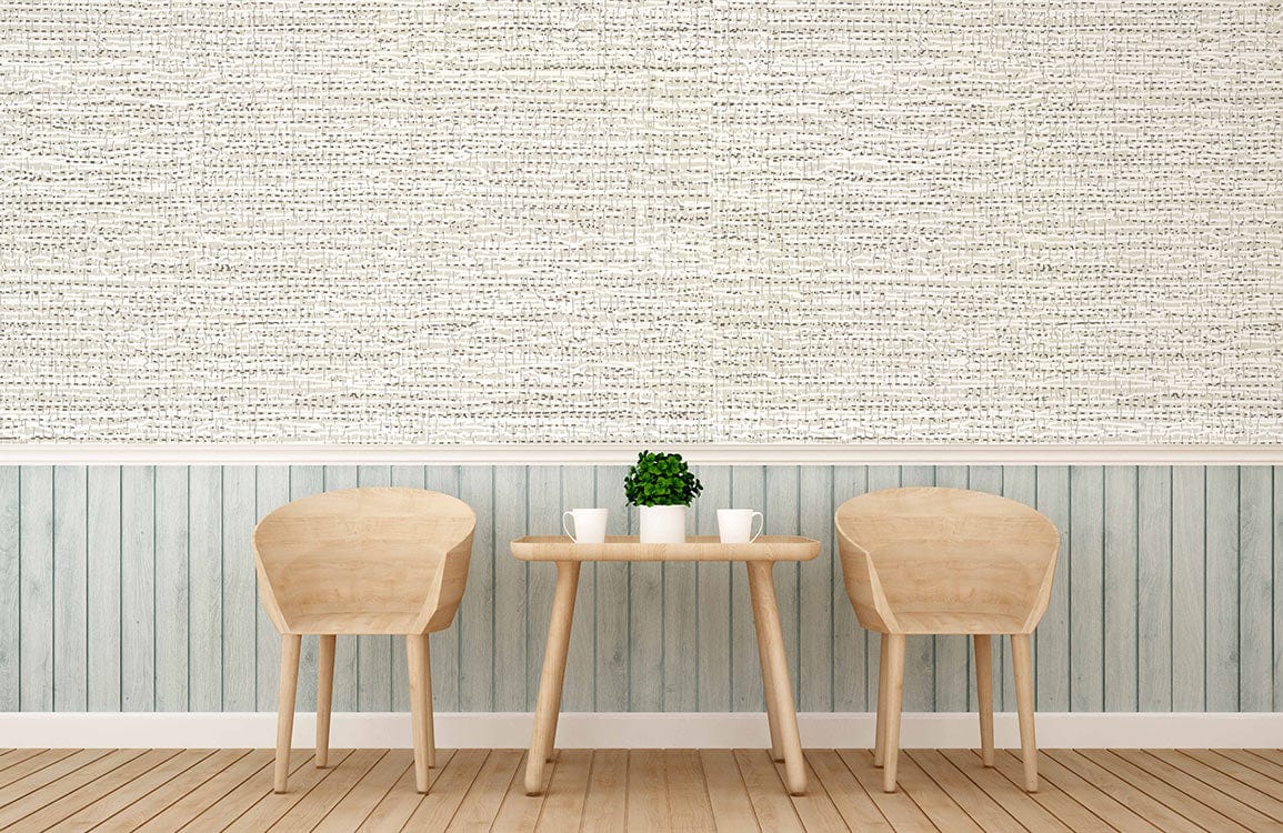 Textured beige linen-effect wallpaper in cosy room with light wood chairs, table, and vertical panelling.