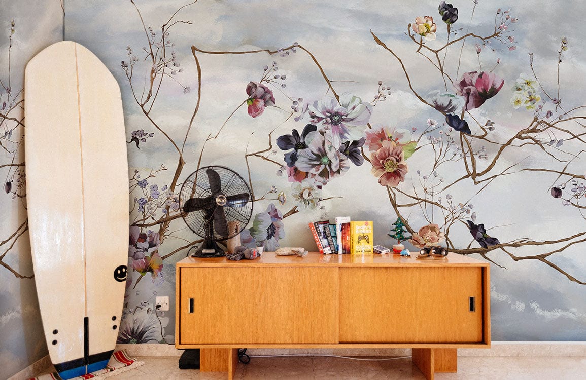 Serene Sky Floral Branches mural wallpaper, pastel design, wooden sideboard, surfboard, fan, bright room.