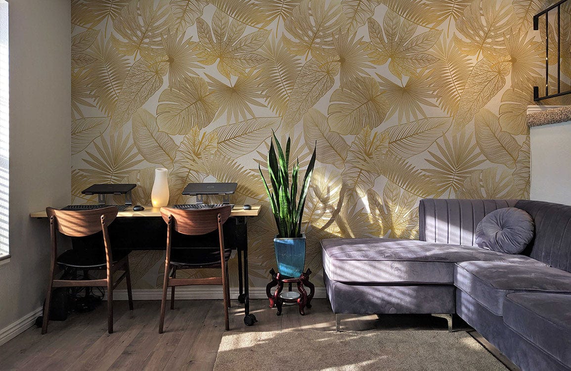 Elegant gold tropical leaf wallpaper in stylish living room, grey corner sofa, wooden chairs, wooden flooring.