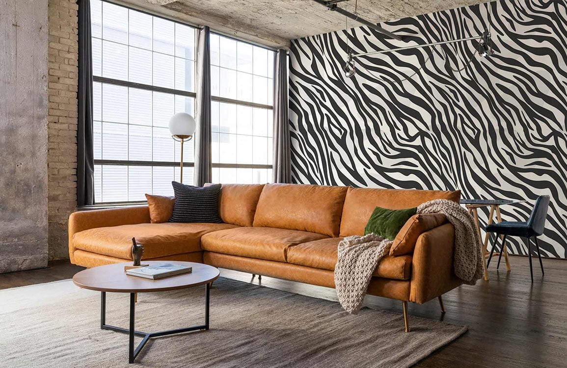 Monochrome Zebra Print Wallpaper, tan sofa, industrial-style windows, modern living room, wooden flooring.