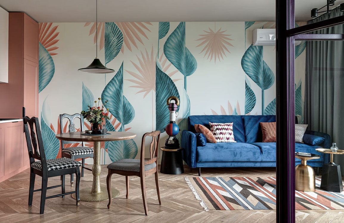 Tropical Blue and Coral Leaf Wallpaper in dining room with blue sofa, wooden chairs, herringbone flooring.