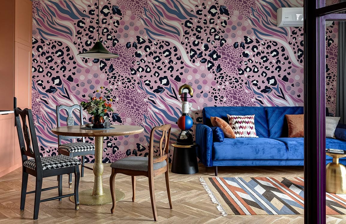 Abstract Pink Leopard Print Wallpaper with vibrant design in living room, blue velvet sofa, wooden flooring.