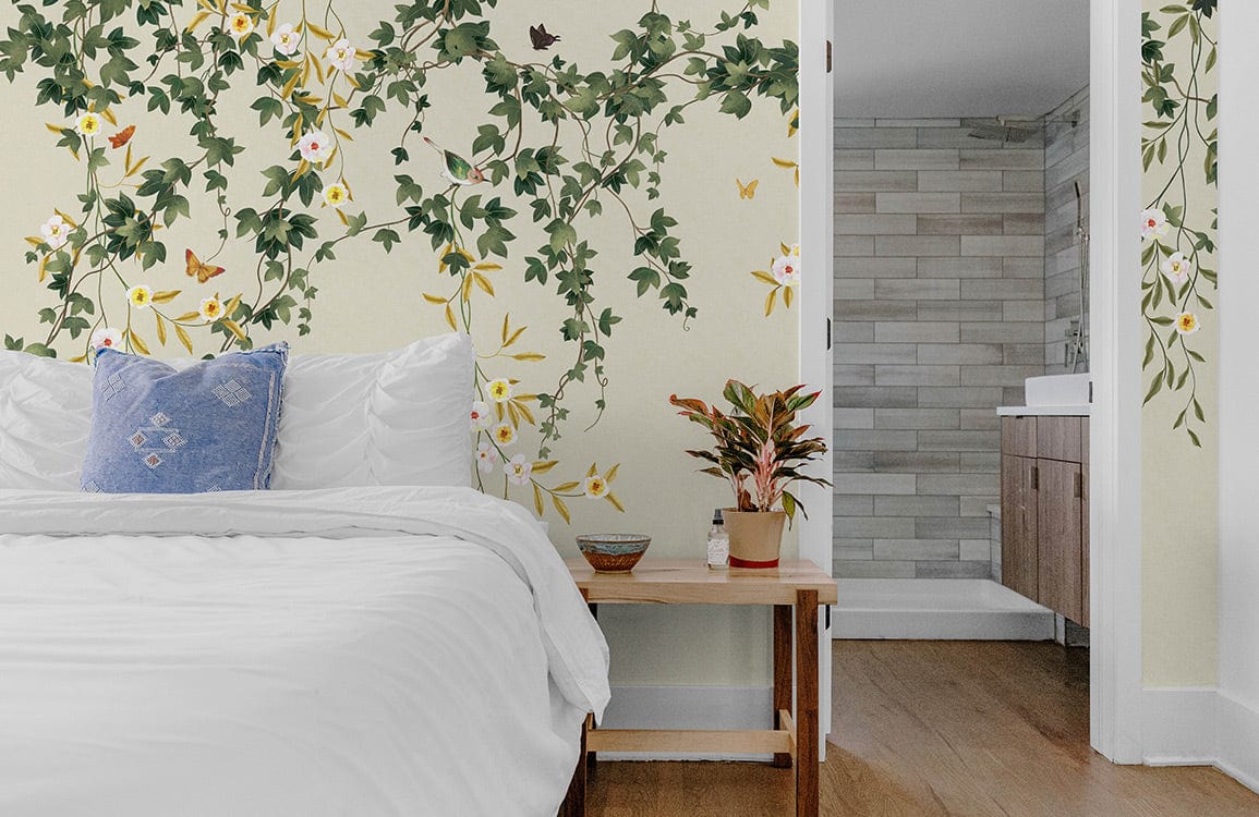 Botanical Garden Vine Mural Wallpaper in green-beige. Bedroom with wooden floor, white bed, blue cushion.