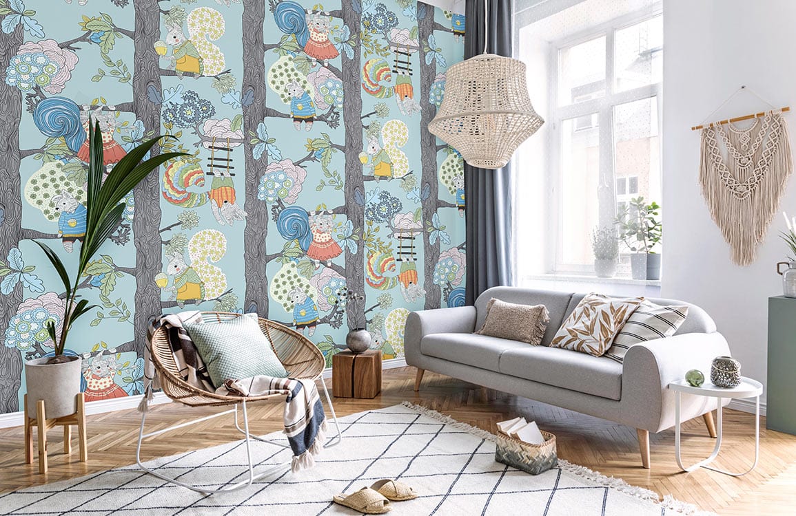 Pastel blue woodland creatures wallpaper in nursery with cosy grey sofa, wicker chair, and wooden flooring.
