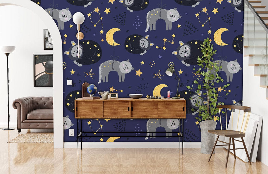 Dreamy Night Sky Cats Mural Wallpaper features navy blue with gold stars, brown console, grey sofa.