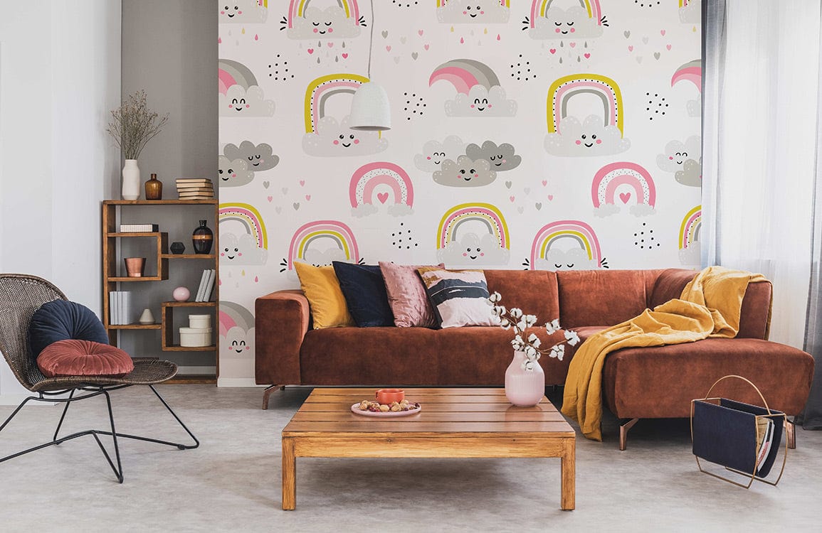 Whimsical pink and grey cloud rainbow mural in children's room, featuring brown sofa and wooden furniture.