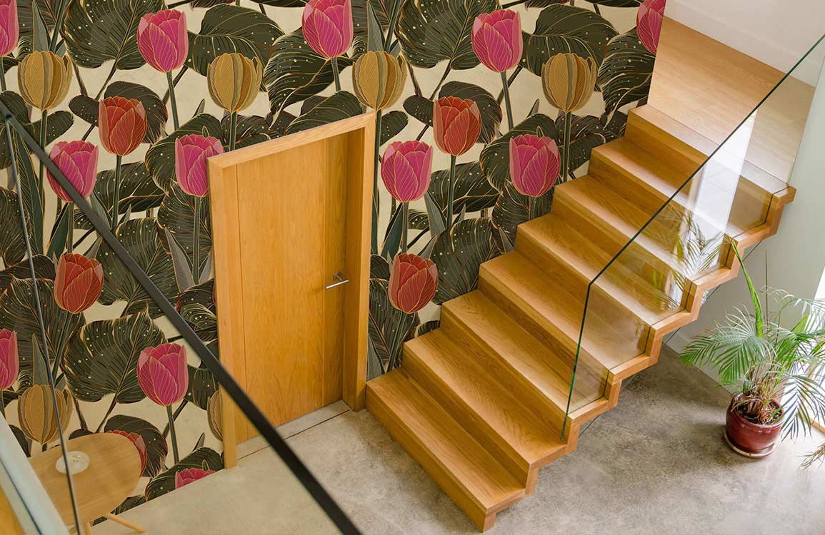 Vintage botanical tulip wallpaper adorning staircase wall, wooden steps, glass railing, potted plant decor.