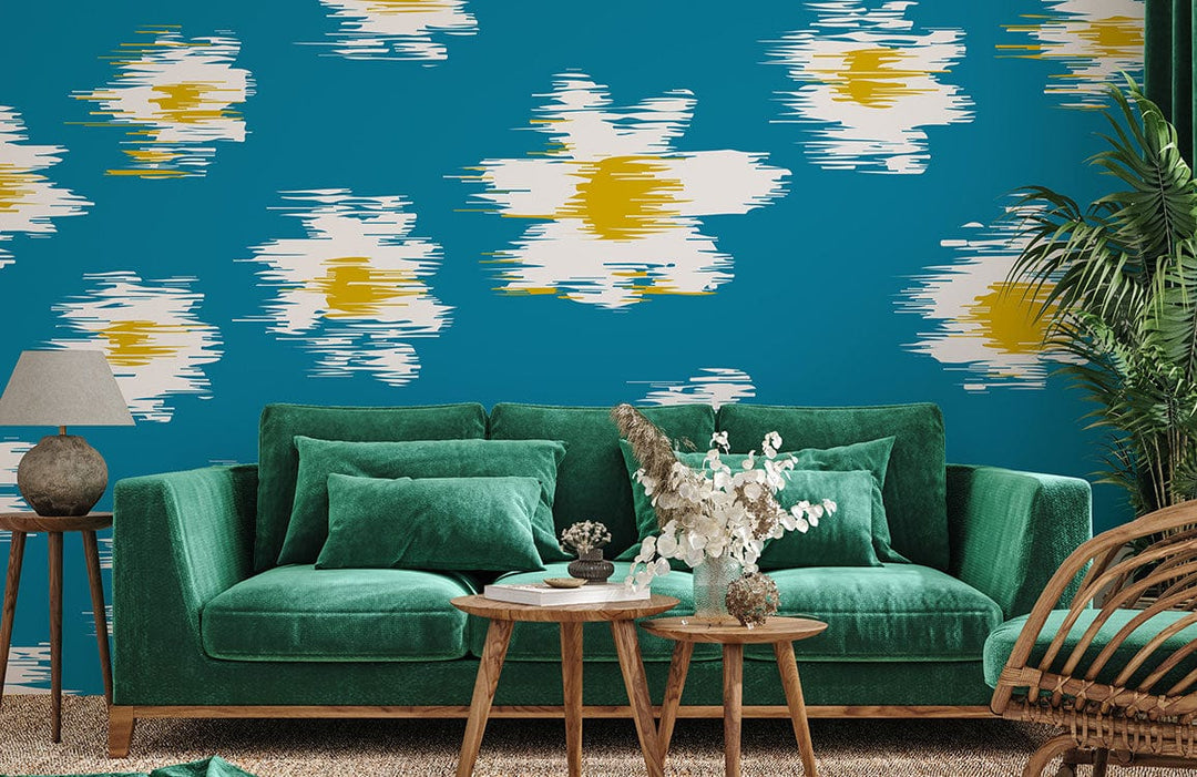 Bold teal floral wallpaper, vintage-style daisies, complemented by green velvet sofa, wicker chair, carpet.