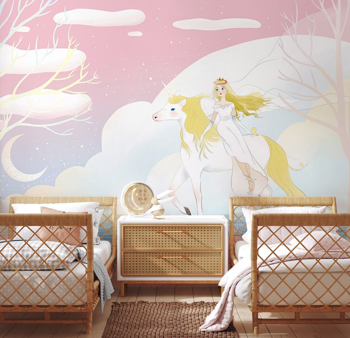 Pastel pink unicorn mural wallpaper in nursery room with wicker furniture, light wood flooring, and rug.