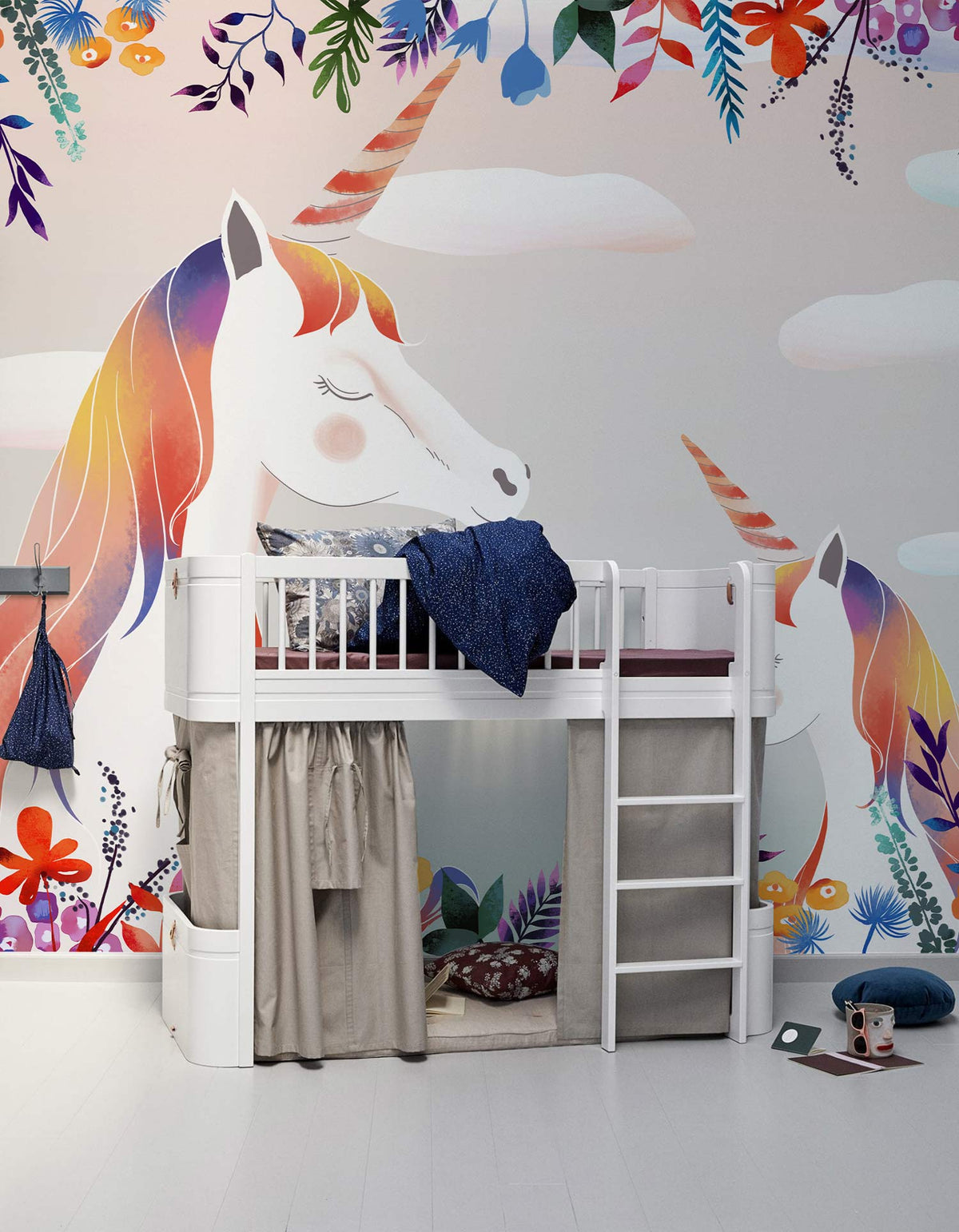 Whimsical unicorn mural wallpaper in child's room with white loft bed, colourful floral design, playful.