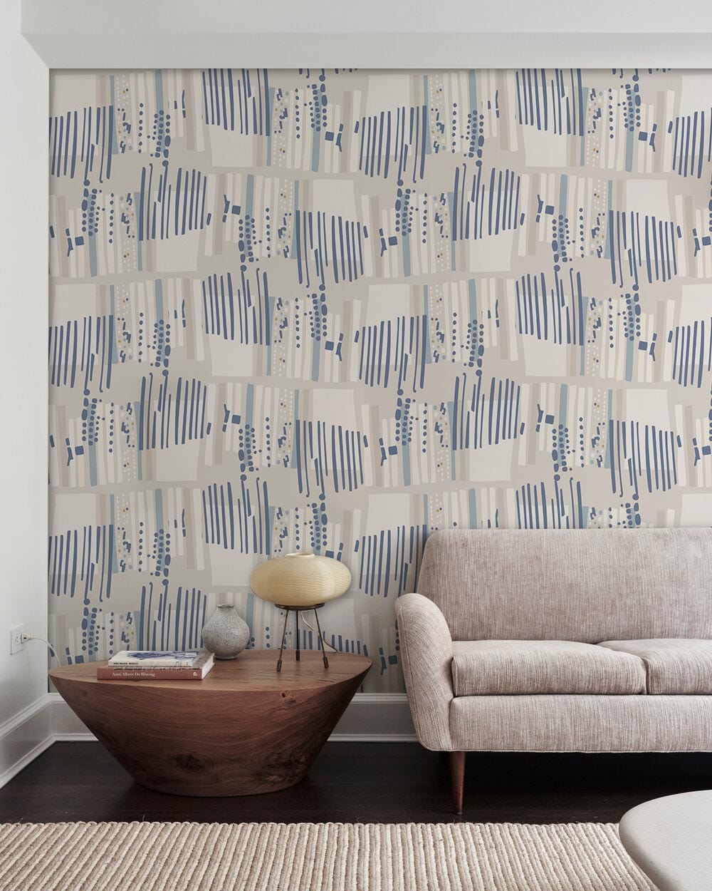 Contemporary beige-blue geometric wallpaper in modern living room, beige sofa, wooden flooring, unique decor.