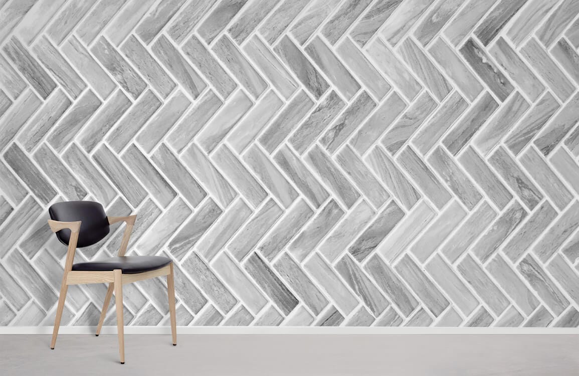 Grey Chevron patterned wallpaper with modern texture, featuring black chair and light floor in a minimalist room.