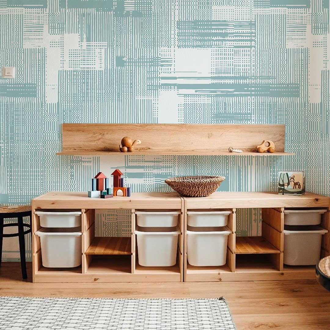 Mint geometric wallpaper with abstract pattern in stylish children's room; features wooden floor and storage.