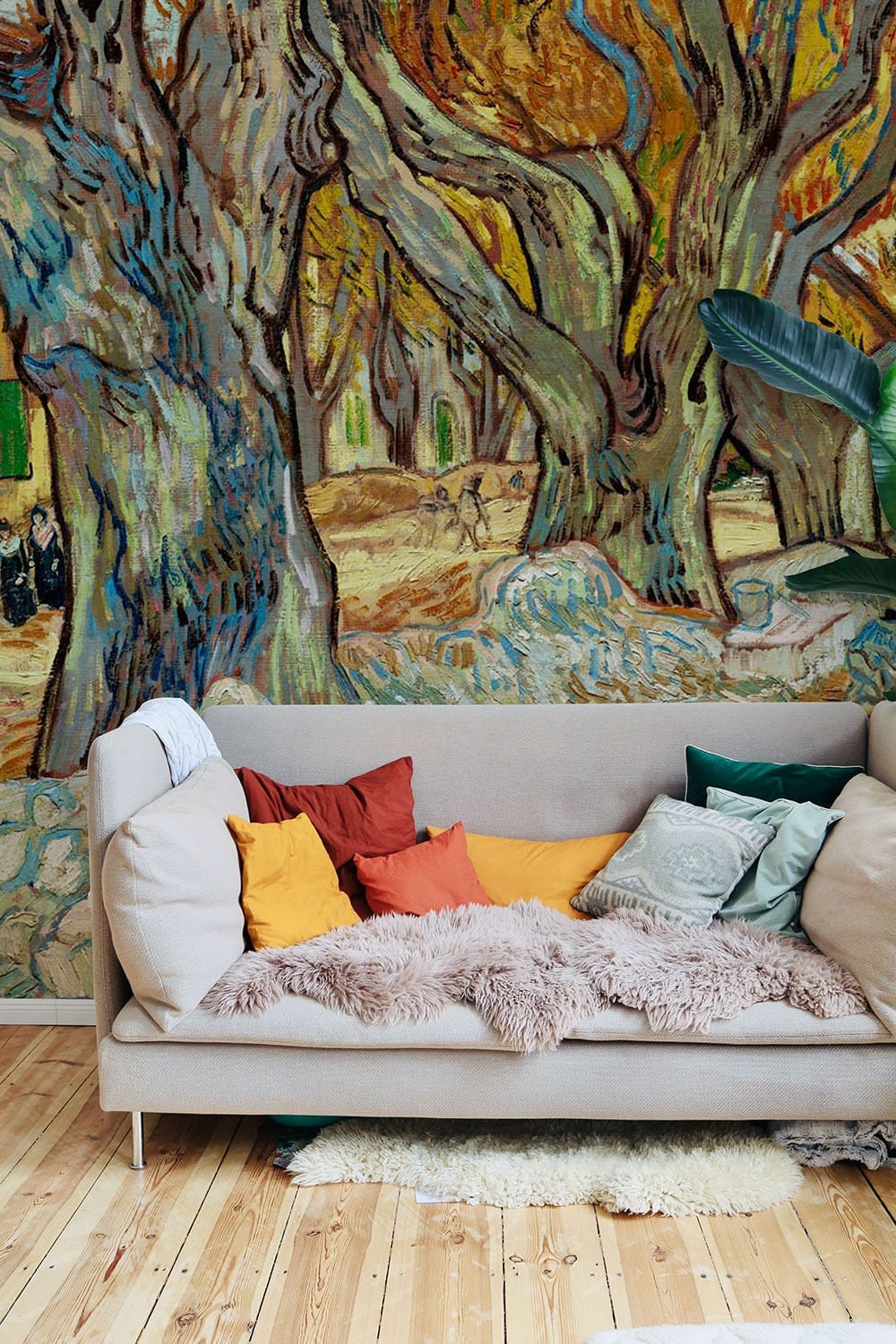 Cosy sofa with cushions in earthy-toned impressionist mural room, wooden flooring, Autumn Avenue Artwork.