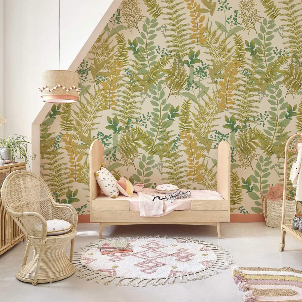 Botanical fern wallpaper in green and earthy tones with wicker chair, pastel bed, and neutral rug.