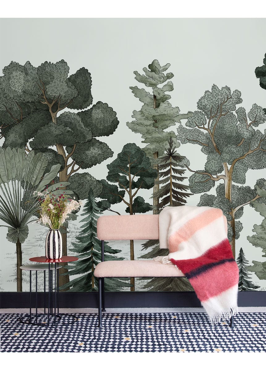Enchanted Forest Green Watercolour Mural Wallpaper in cosy room with pink sofa, patterned rug, side table.
