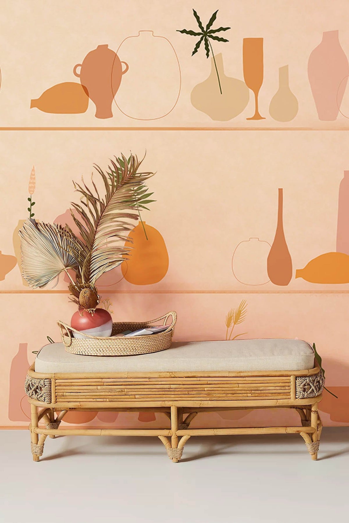 Minimalist pastel pottery mural wallpaper in modern room; wicker bench, soft peach tones.