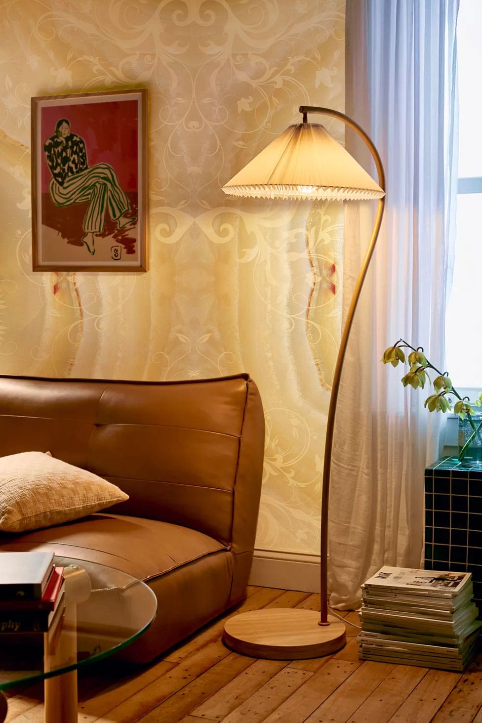 Elegant cream marble wallpaper, brown leather sofa, wooden flooring, and stylish floor lamp in cosy room.