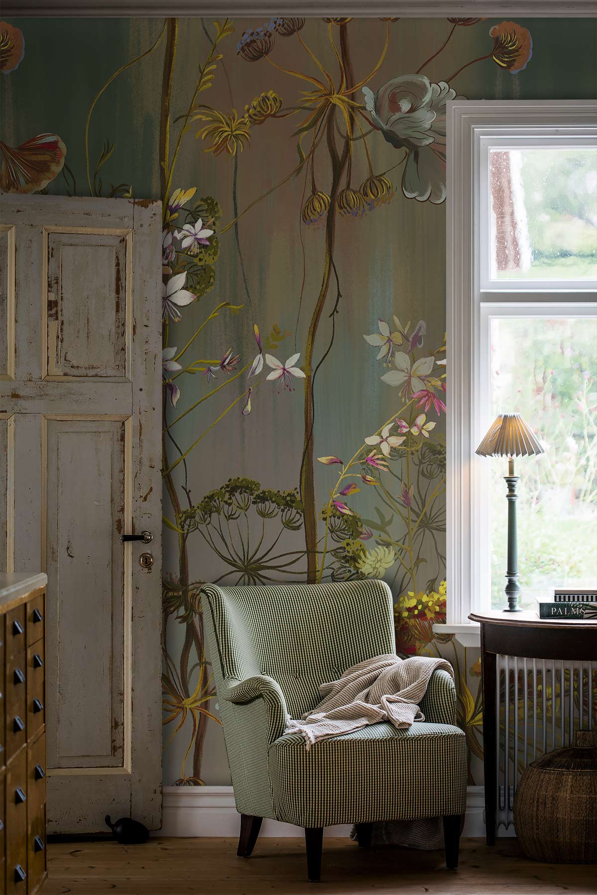 Elegant autumnal botanical wallpaper with armchair, rustic wood door, and vintage lamp in cosy room.