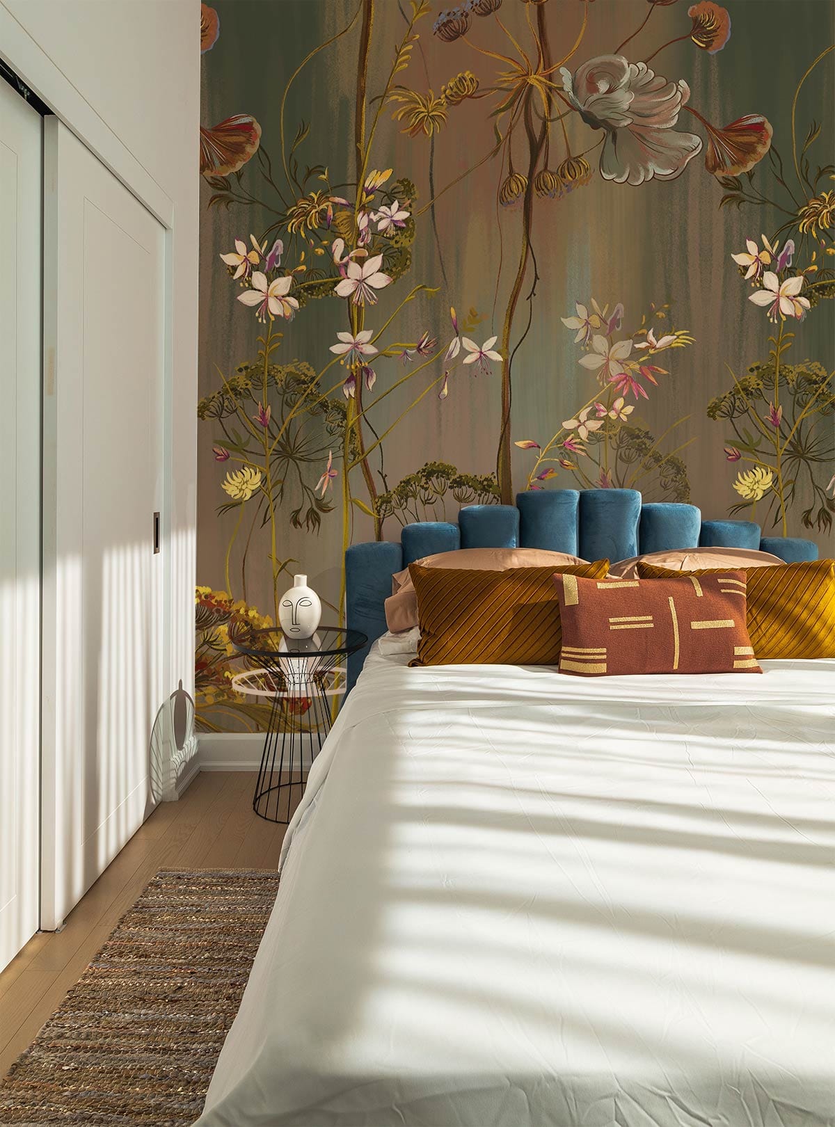 Elegant botanical wallpaper, earthy tones, botanical design, bedroom setting, blue velvet headboard, wooden flooring.