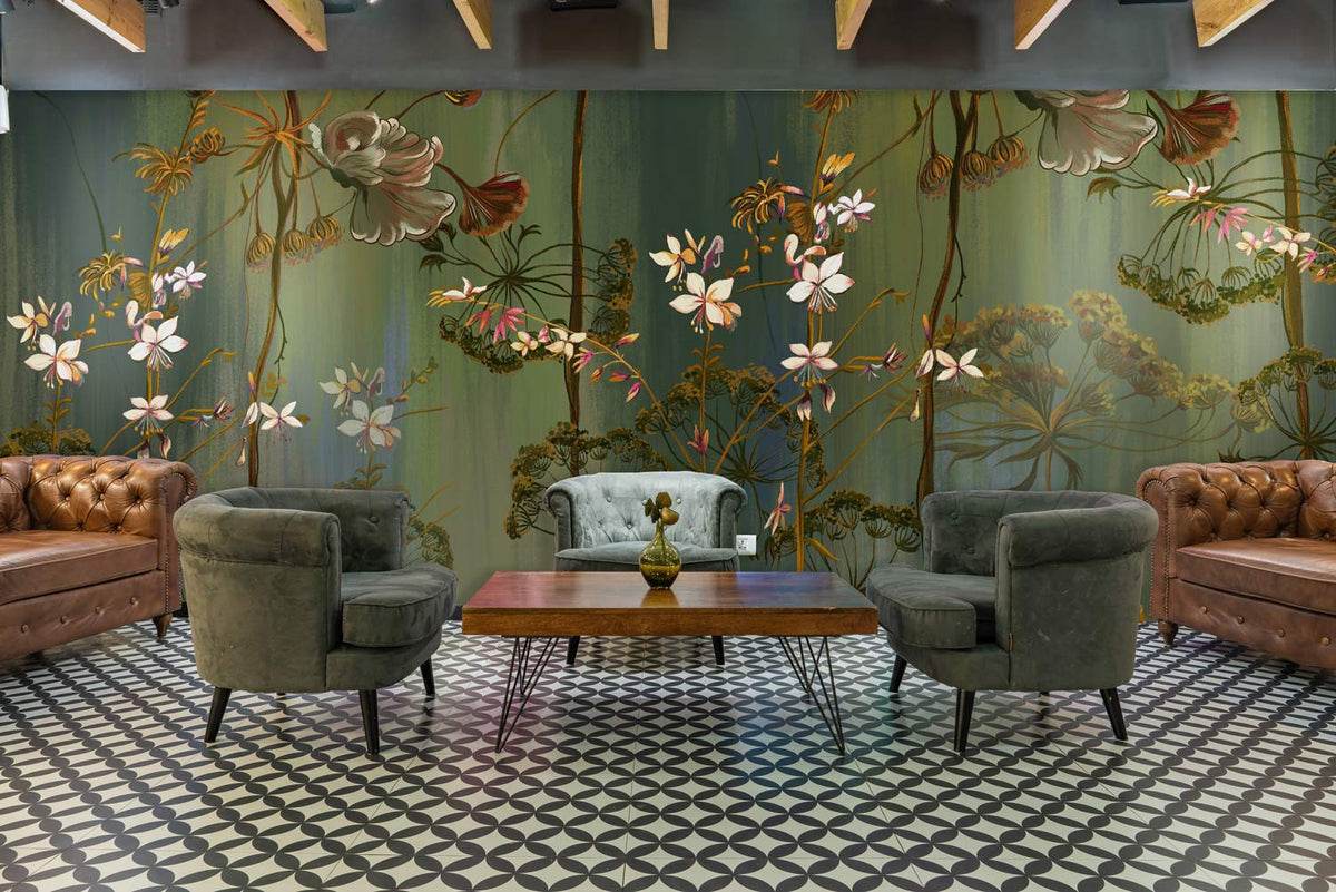 Botanical Dreamscape green floral mural wallpaper in elegant lounge, vintage sofas, patterned flooring.