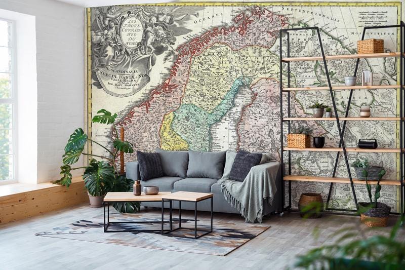 Vintage Scandinavian map mural wallpaper with grey sofa, industrial shelving, and wooden flooring in living room.