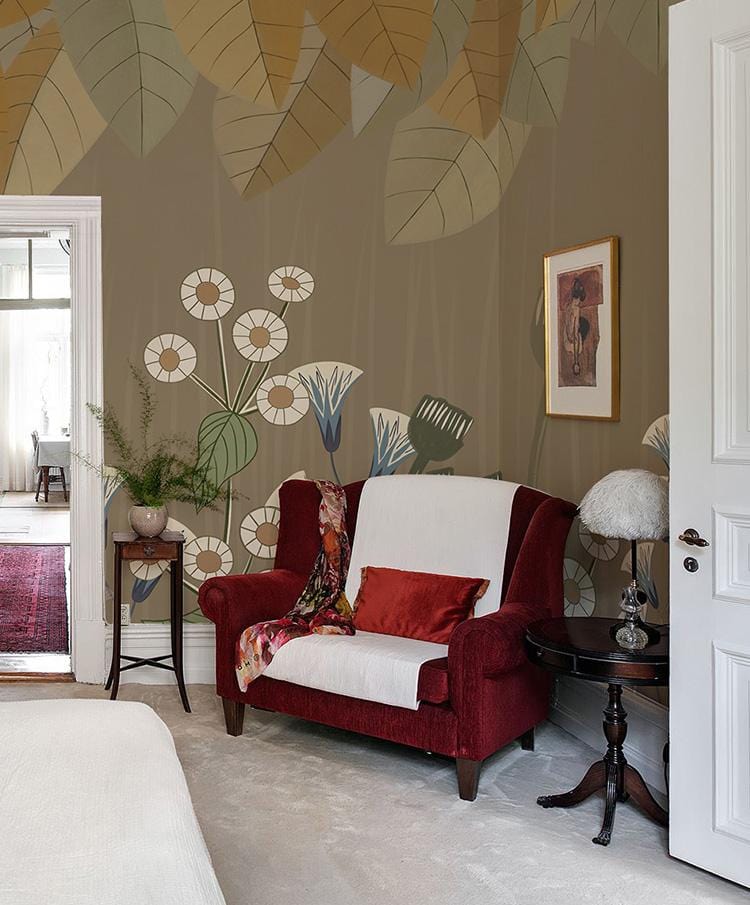 Botanical Harmony mural wallpaper featuring earthy leaves behind red armchair in classic style bedroom.
