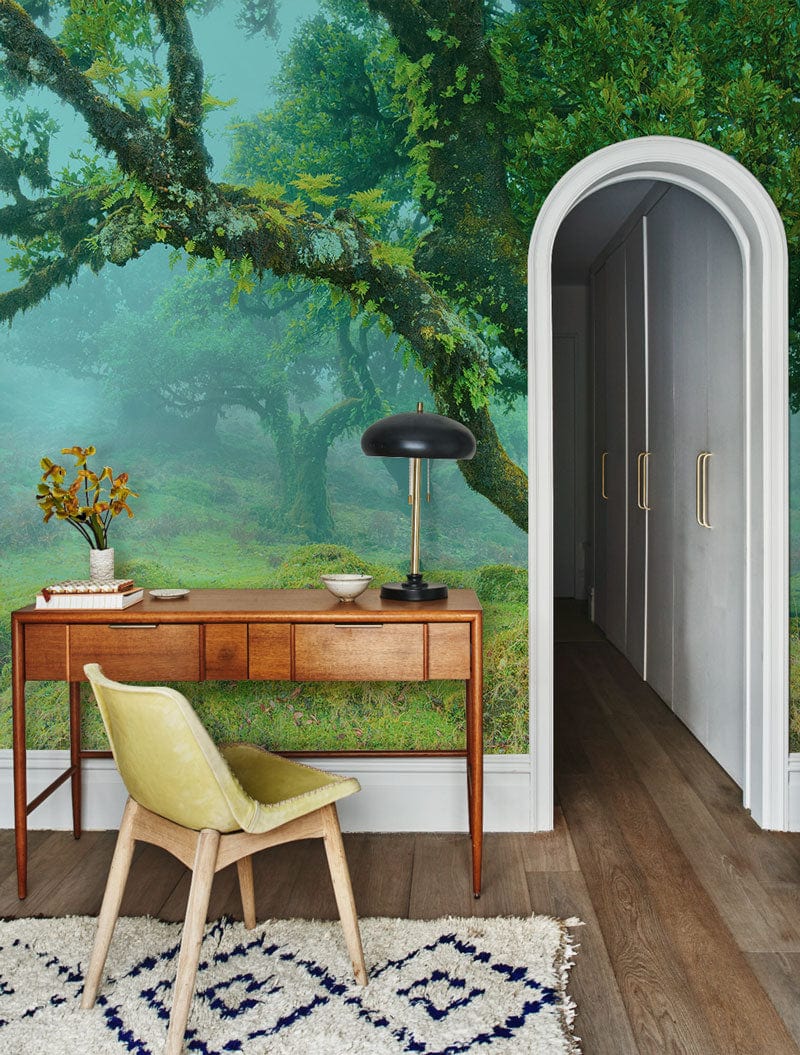 Enchanted Misty Forest Green Wallpaper, wooden desk, arched doorway, grey walls, light wooden floor.