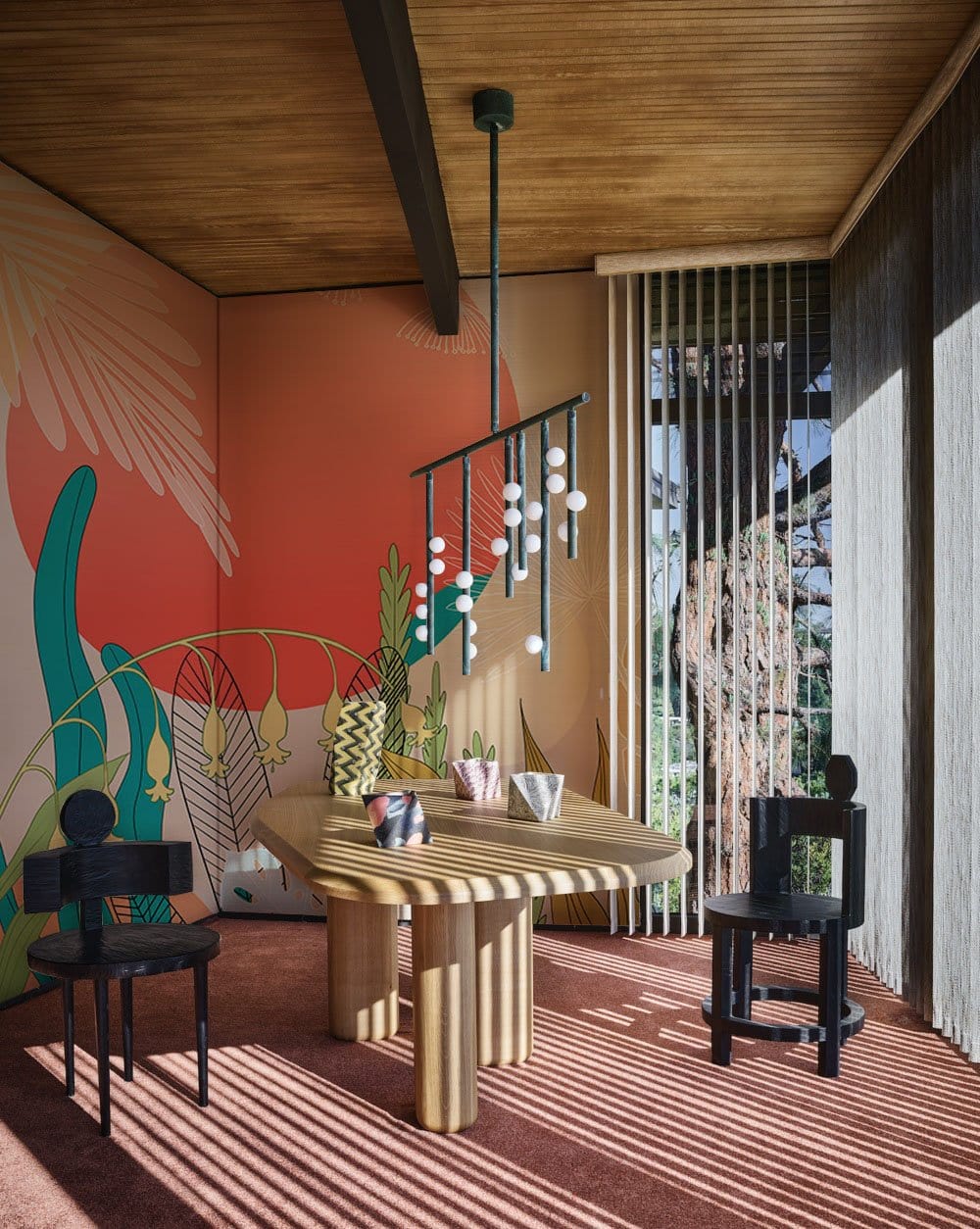 Vibrant tropical mural wallpaper with coral, turquoise accents; modern dining room, wooden table, black chairs.