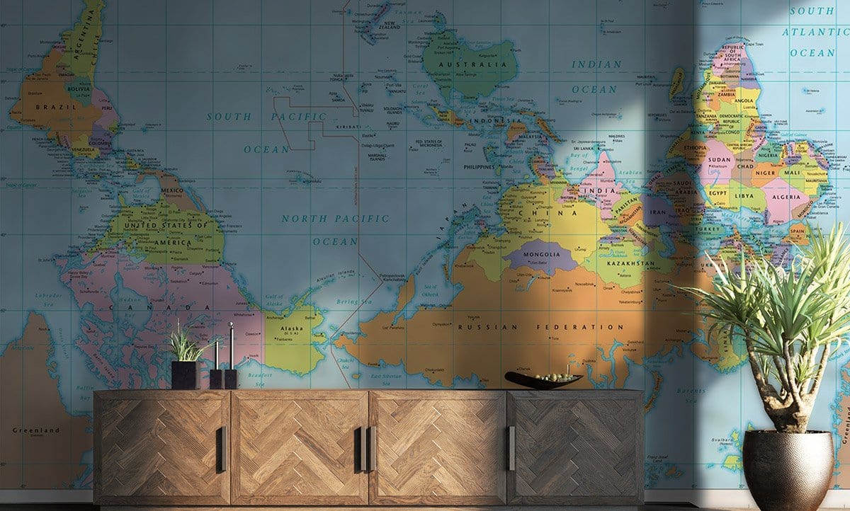 Vibrant Upside Down World Map Wallpaper in living room with wooden sideboard, plants, and blue decor.