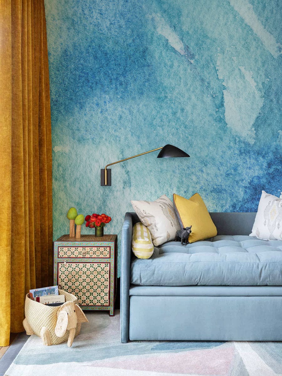 Blue Watercolour Abstract Mural with modern oceanic design, blue sofa, and mustard curtains in living room.