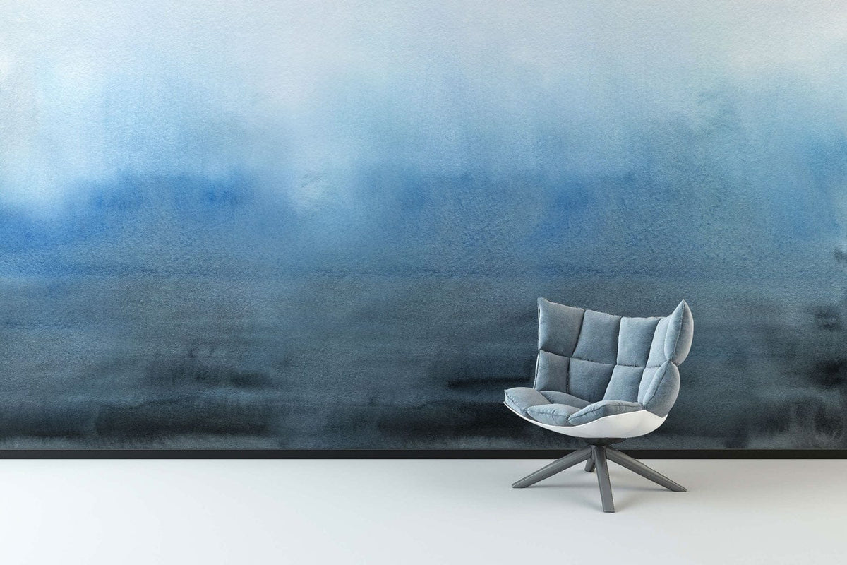 Tranquil blue watercolour mural wallpaper in modern room with sleek grey chair and minimalist flooring.