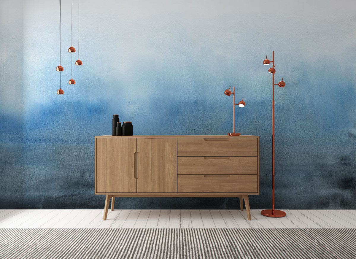 Tranquil Blue Watercolour Gradient Mural Wallpaper, wooden sideboard, pendant and standing lamps, striped rug.