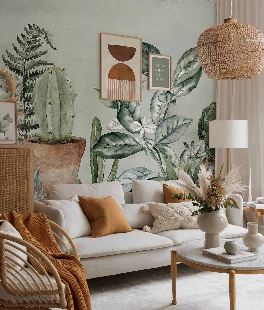 Botanical mural wallpaper in a cosy living room with white sofa, wicker chairs, and soft lighting.