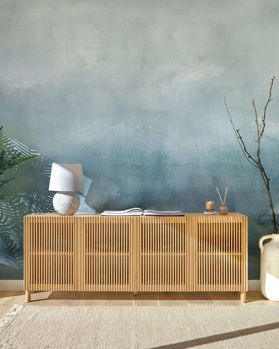 Serene Watercolour Misty Blue Ombre wallpaper, wooden sideboard, neutral carpet, minimalist decor, tranquil ambiance.